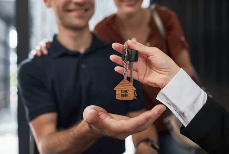 Consegna di chiavi di una casa a persone felici
