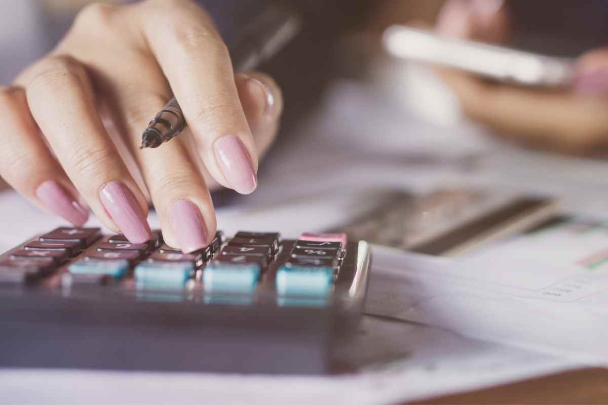 Dita che digitano sulla calcolatrice