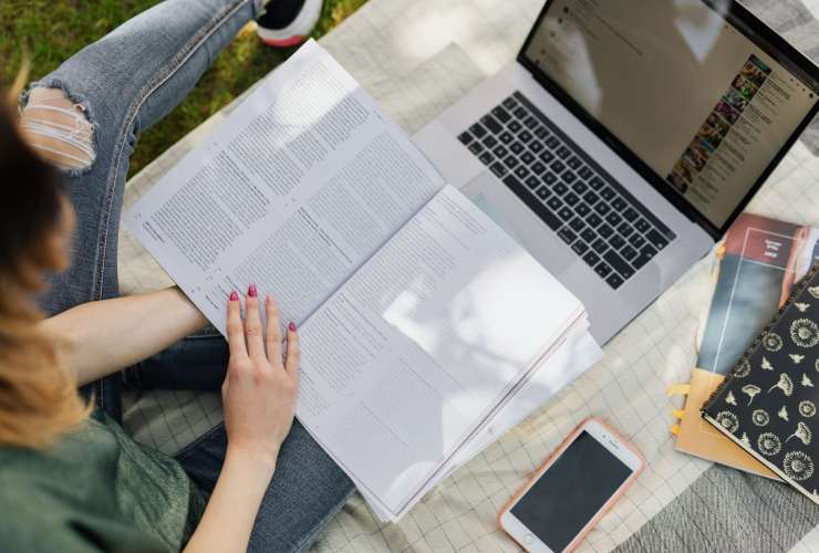 Persona che studia leggendo e consultando il web