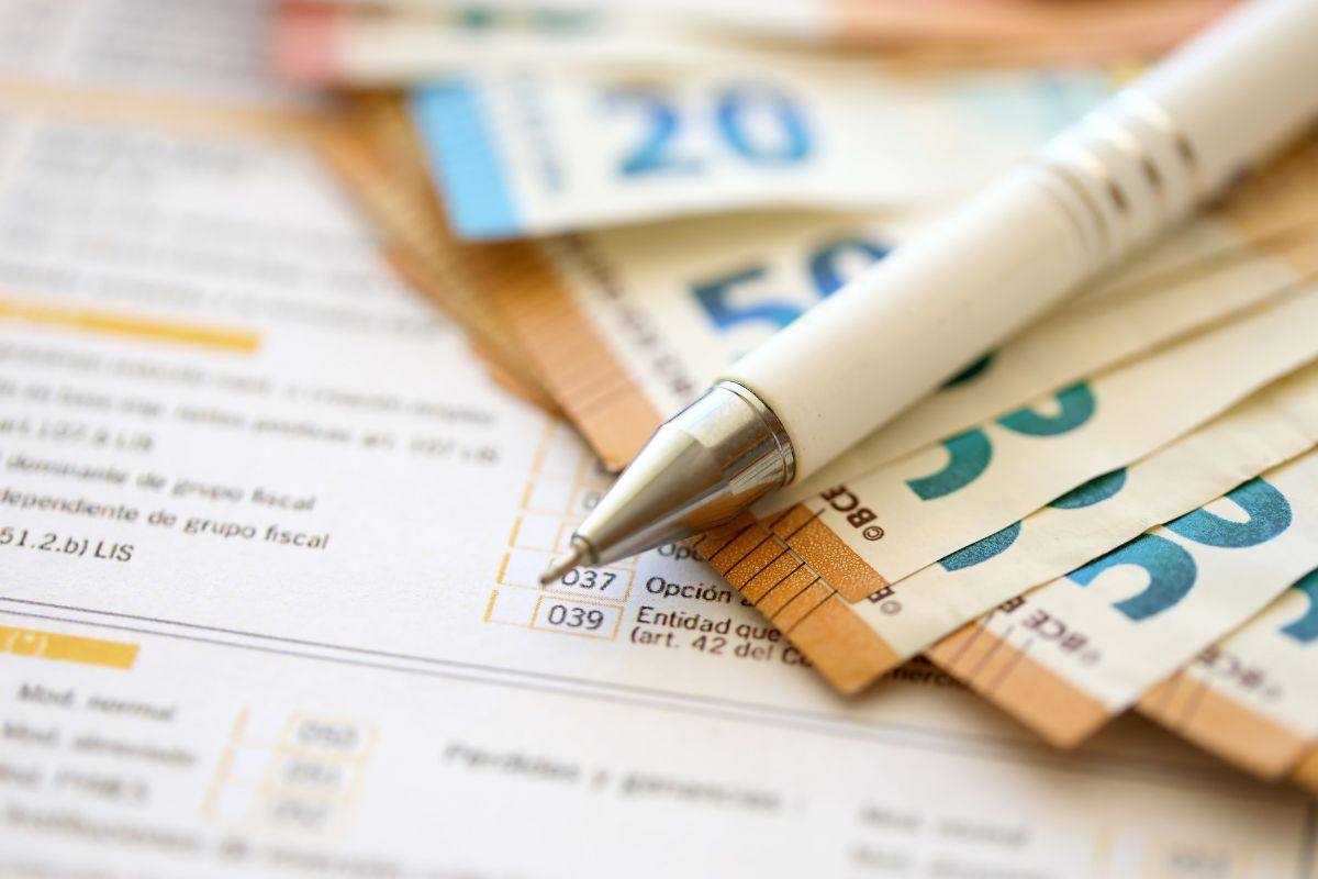 Banconote, penna e modulo dichiarazione dei redditi