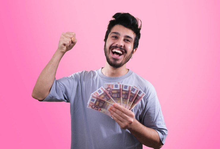 Persna che gioisce mantenendo delle banconote