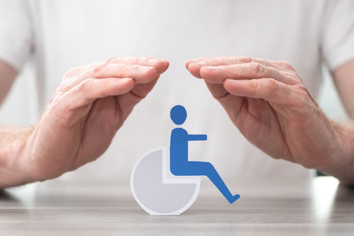 Mani che proteggono il simbolo della disabilità