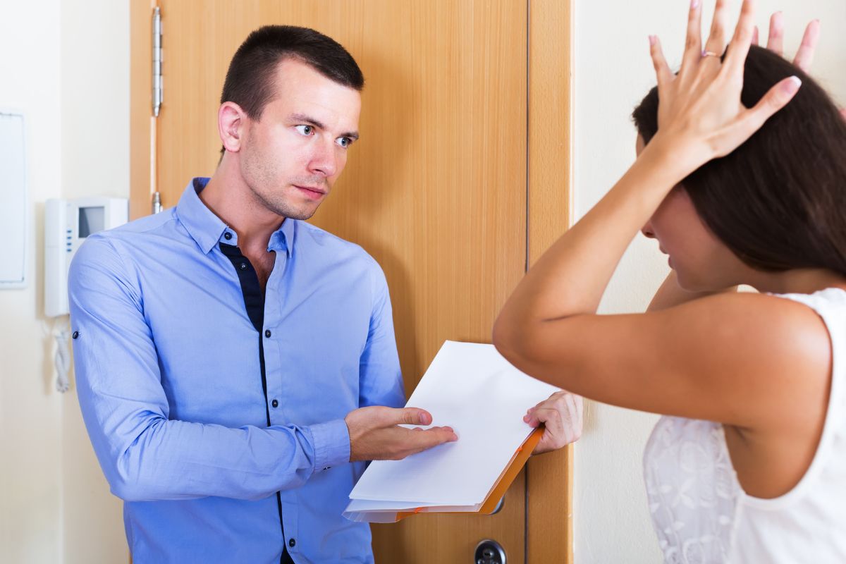 Persona disperata che discute con un altro che gli mostra un documento