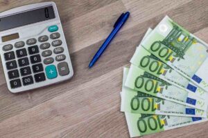 Calcolatrice, banconote e penna