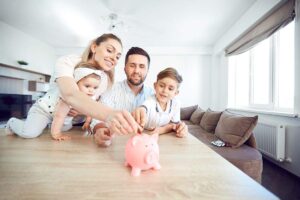 Famiglia che mette una moneta in un slavadanaio