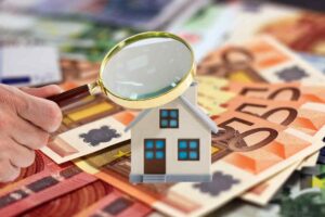 Soldi, casa e lente di ingrandimento