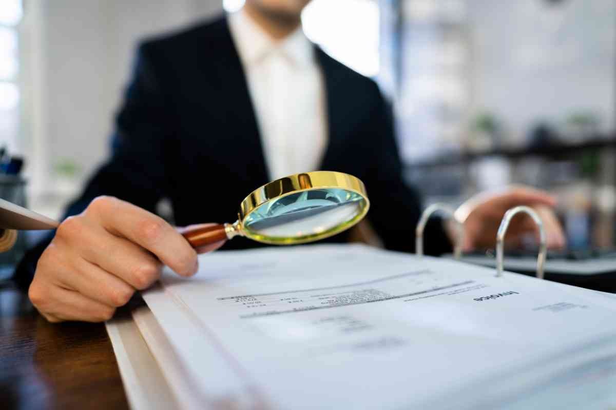 Persona con lente di ingrandimento e documenti