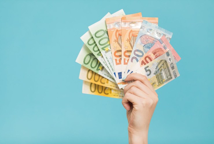 Persona che mantiene in mano delle banconote