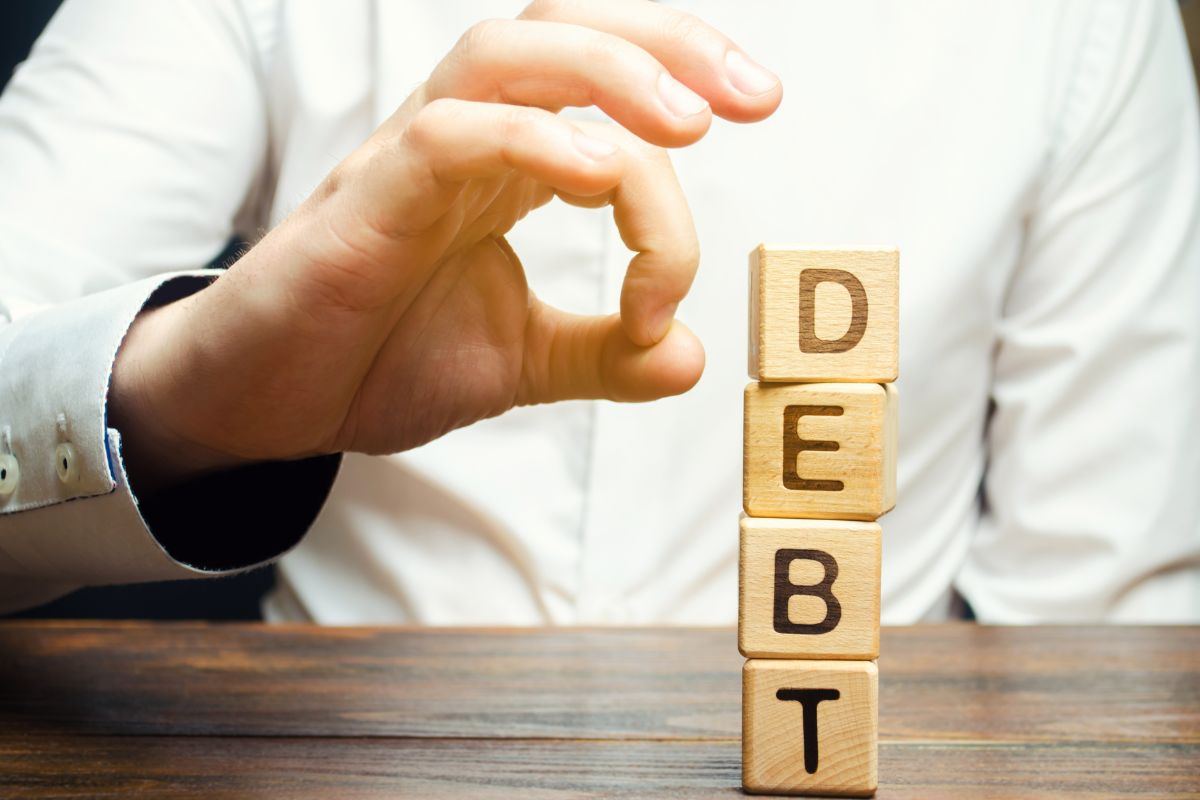 Scritta DEBT sopra dei dadi