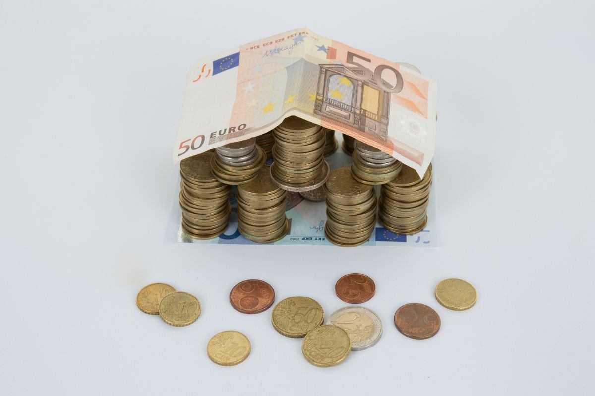 Monete e banconote raccolte a forma di casa