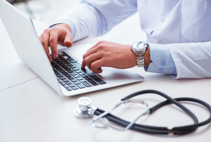 Medico che scrive al pc