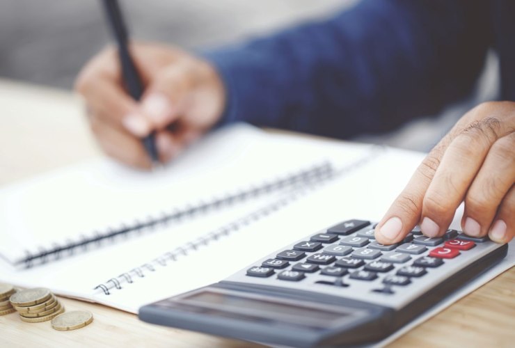 Persona che prende appunti e fa dei calcoli