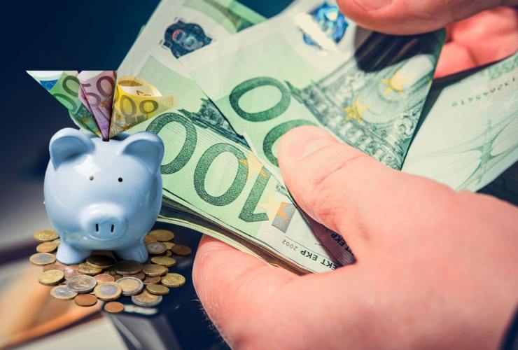 Persona che conta banconote e salvadanaio