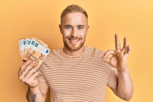 Persona che fa OK con banconote in mano da 50 euro
