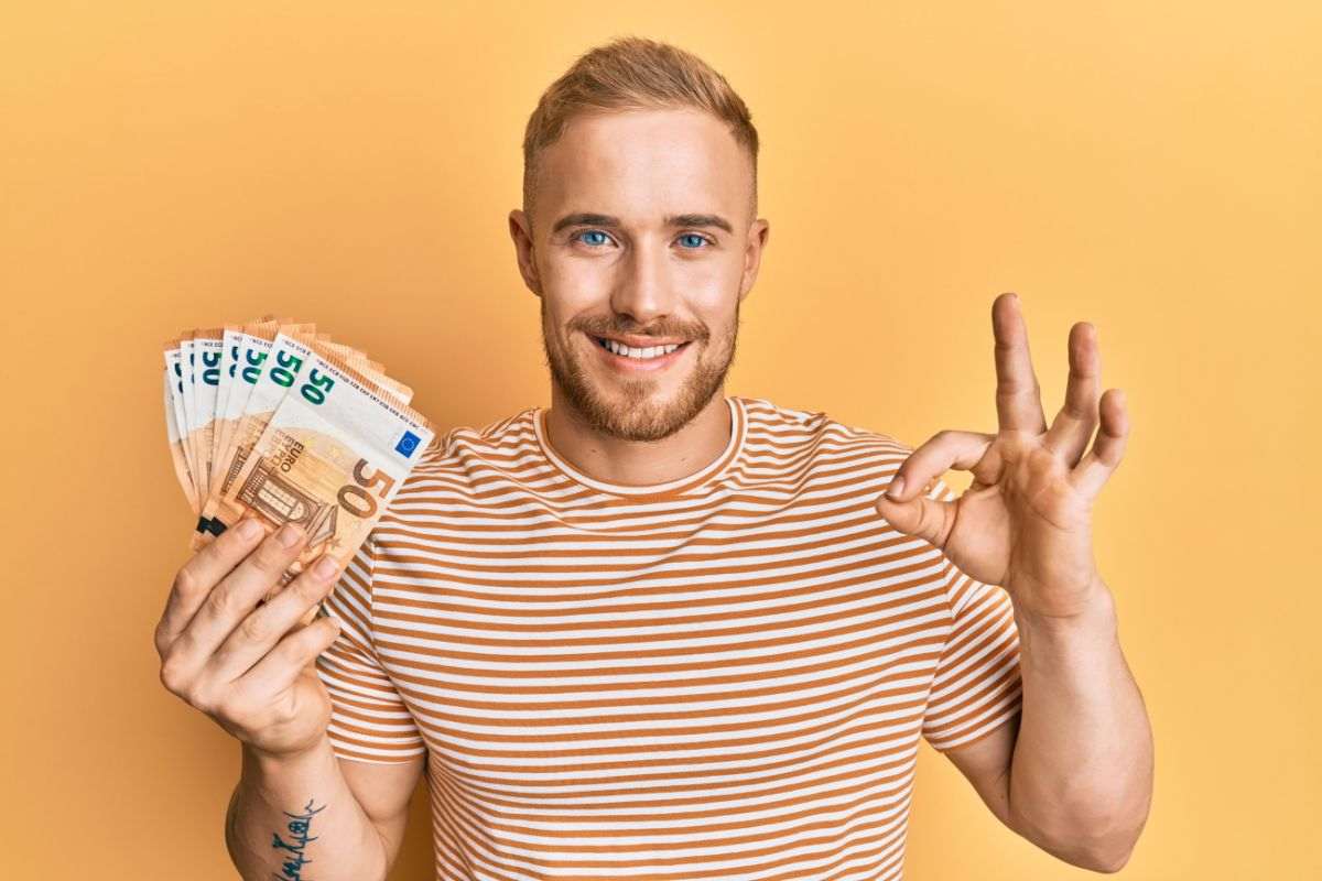 Persona che fa OK con banconote in mano da 50 euro