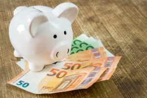 Salvdanaio e banconote da 50 e 100 euro