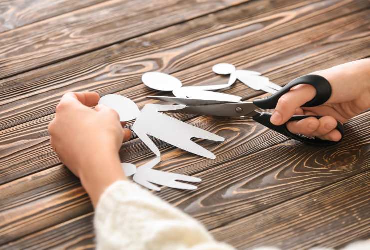 Persona che taglia a metà figure di una famiglia