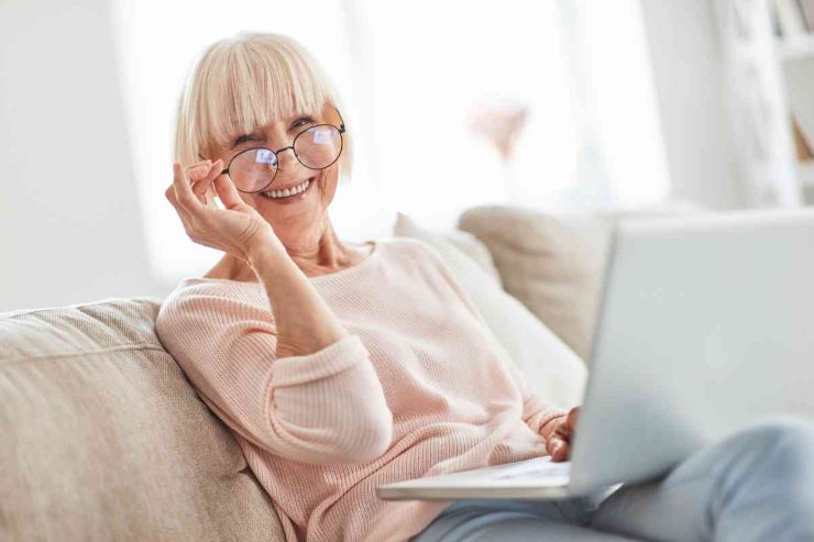 Pensionata sorridente al pc 