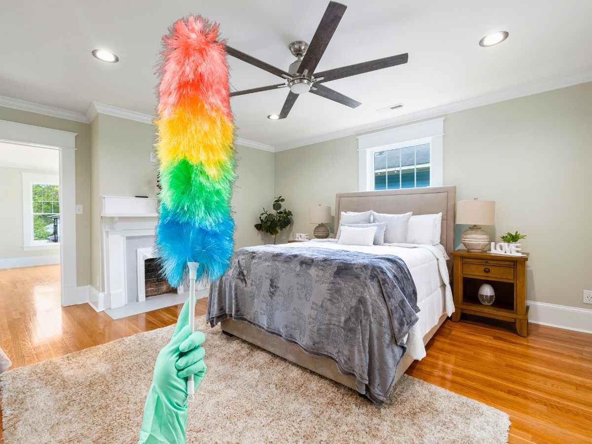 sfondo camera da letto con ventilatore e mano con piumino per la polvere colorato