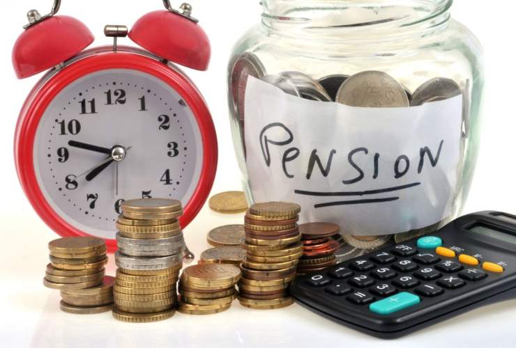 sveglia, vasetto pieno di monete con scritta pension., calcolatrice e monete
