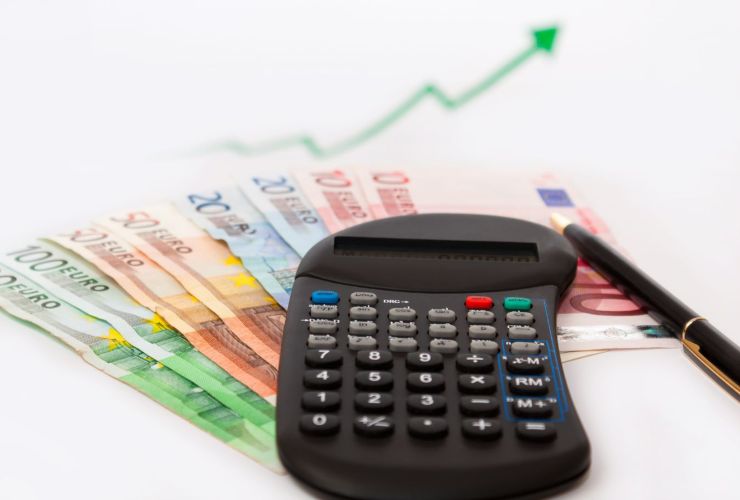 Calcolatrice, banconote e freccia